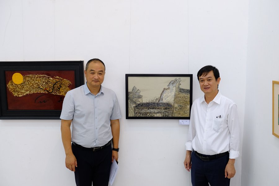 GS.TS Vương Nghi - Phó Viện trưởng Viện Mỹ thuật thuộc Đại học Sư phạm An Huy (bên trái) và TS Ngô Việt Hùng - Hiệu trưởng Trường Đại học Mỹ thuật TP.HCM tại triển lãm