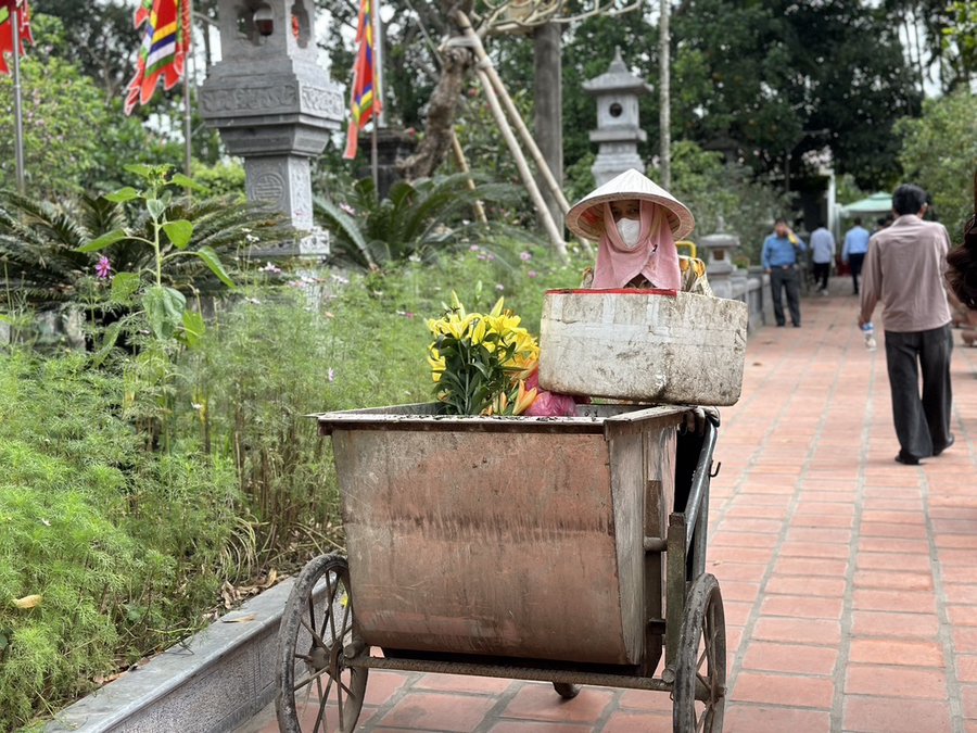 Trong khuôn viên Khu di tích đền Trần, các cô lao công, vệ sinh môi trường miệt mài thu gom rác thải, đảm bảo vệ sinh môi trường, mỹ quan trong ngày Khai ấn
