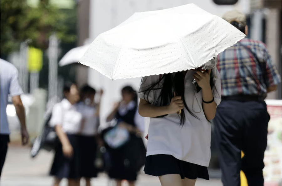 Người dân đi bộ trong ngày nắng nóng tại Kumagaya, tỉnh Saitama (Nhật Bản) vào tháng 8 năm ngoái. Ảnh: Kyodo.