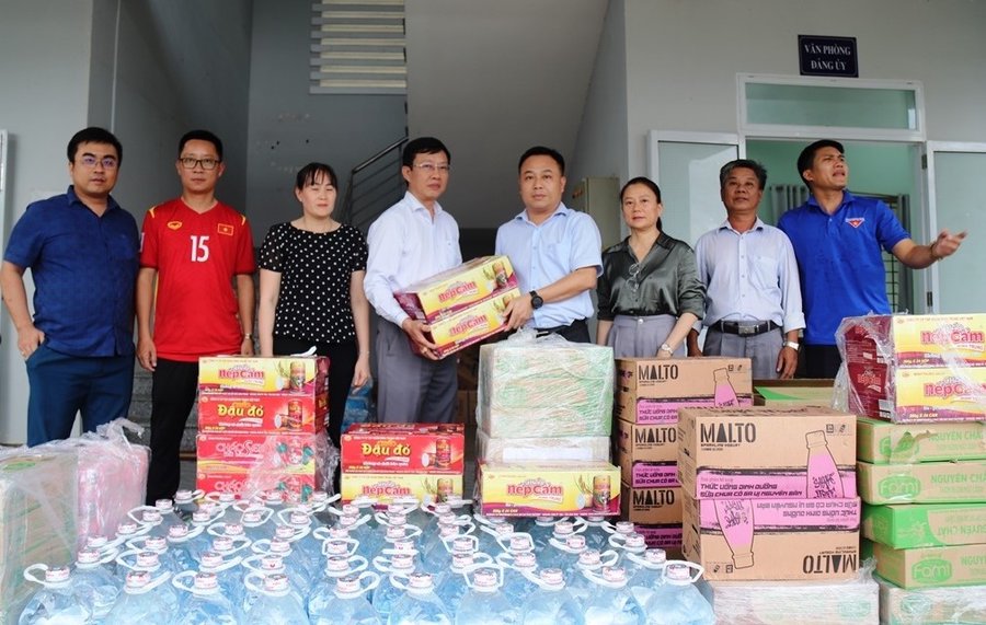 Nguyễn Đức Trí, Bí thư xã Diên Lâm (trái) tiếp nhận 2 tấn nhu yếu phẩm do các đơn vị gửi tặng người dân vùng lũ tại địa phương