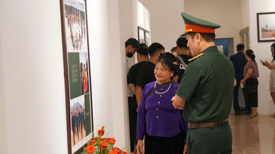 Bà Hoàng Thị Xơi chia sẻ về các bức ảnh với khách tham quan. Ảnh: Minh Trang